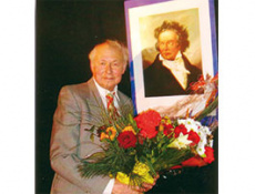 Портрет Александра Мерлина на фоне афиш